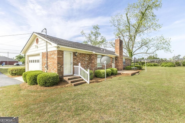 2237 W Elm St, Wrightsville, GA 31096 - exterior space with driveway, a chimney, brick siding, an attached garage, and a front yard