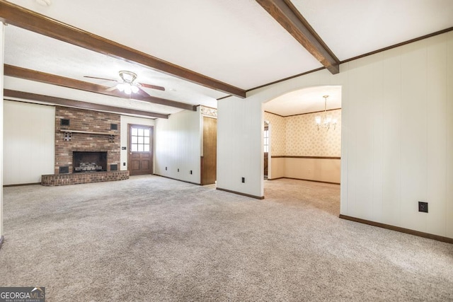 2237 W Elm St, Wrightsville, GA 31096 - unfurnished living room featuring ceiling fan with notable chandelier, beam ceiling, a brick fireplace, and carpet