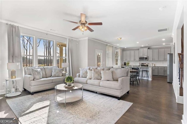 living area with visible vents, dark wood-style flooring, a ceiling fan, crown molding, and recessed lighting