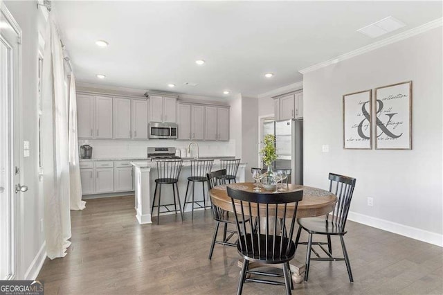 dining space featuring crown molding, baseboards, recessed lighting, and dark wood finished floors