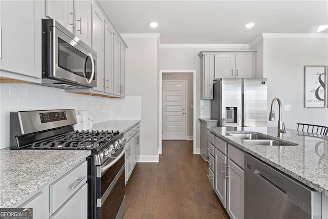 kitchen featuring ornamental molding, backsplash, light stone countertops, stainless steel appliances, and a sink