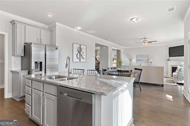 kitchen with visible vents, a sink, appliances with stainless steel finishes, a ceiling fan, and crown molding