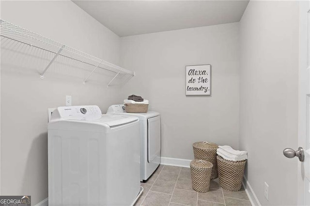 laundry area featuring laundry area, light tile patterned floors, baseboards, and washer and clothes dryer