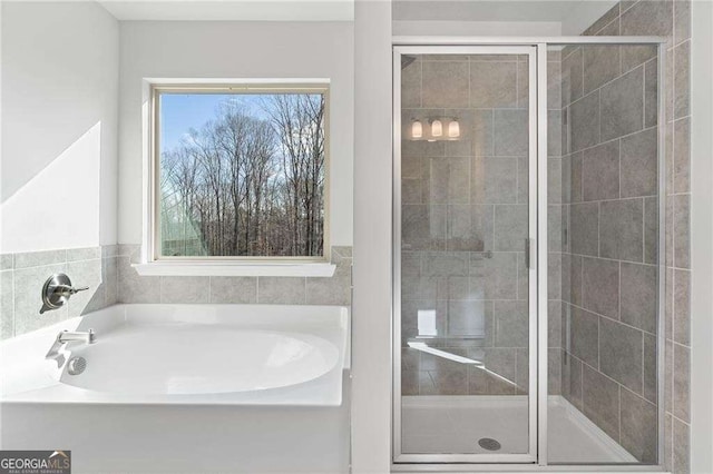 bathroom featuring a bath and a stall shower