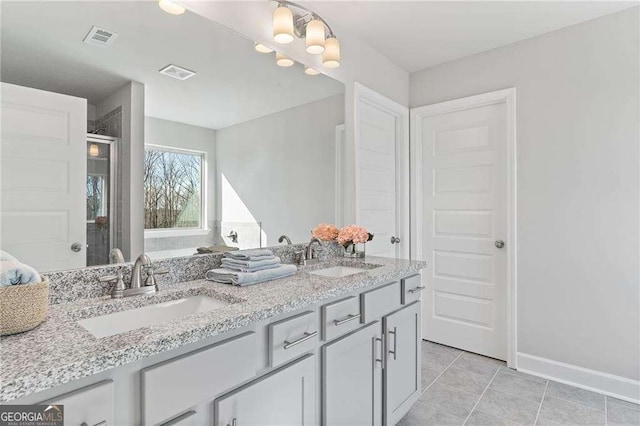 full bath with baseboards, a sink, and visible vents