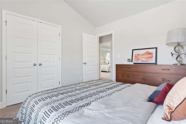 bedroom with a closet, carpet flooring, and lofted ceiling