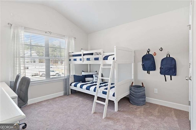 carpeted bedroom with baseboards and lofted ceiling