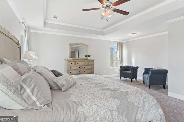 carpeted bedroom with a tray ceiling, baseboards, and visible vents