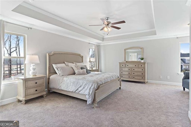 bedroom with carpet, multiple windows, a tray ceiling, and crown molding