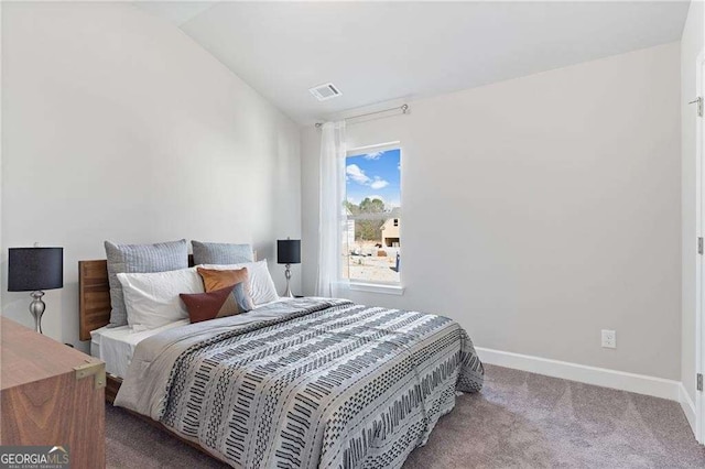 carpeted bedroom with baseboards, lofted ceiling, and visible vents