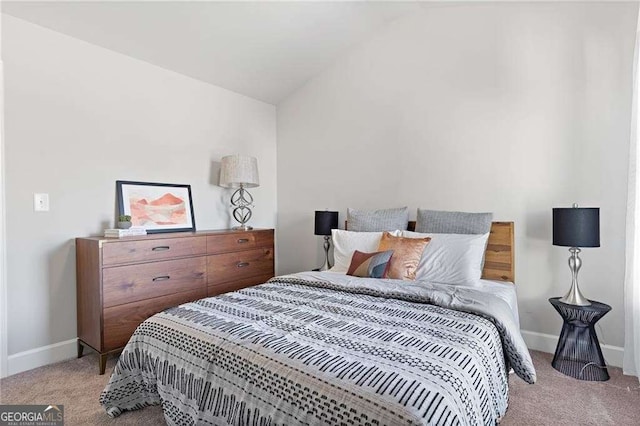 bedroom featuring baseboards, light colored carpet, and lofted ceiling