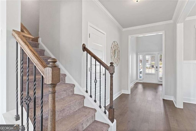 foyer entrance with dark wood-style flooring, baseboards, ornamental molding, and stairway