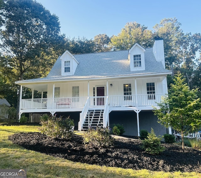 view of front of home featuring covered porch, stairway, board and batten siding, and a chimney