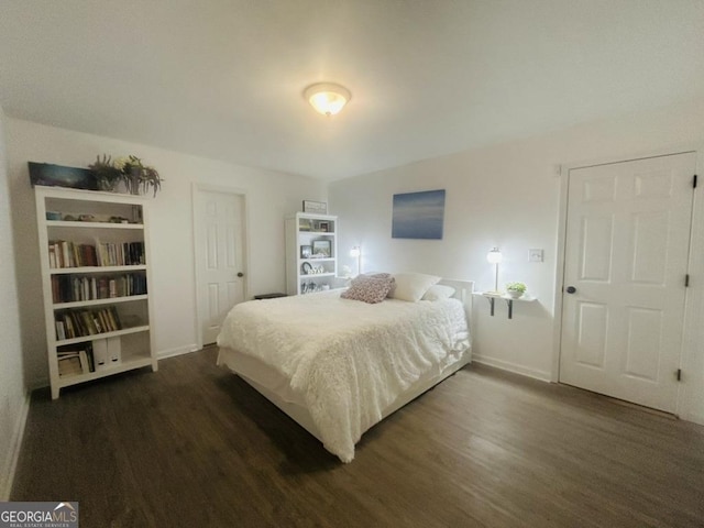 bedroom featuring dark wood-type flooring and baseboards