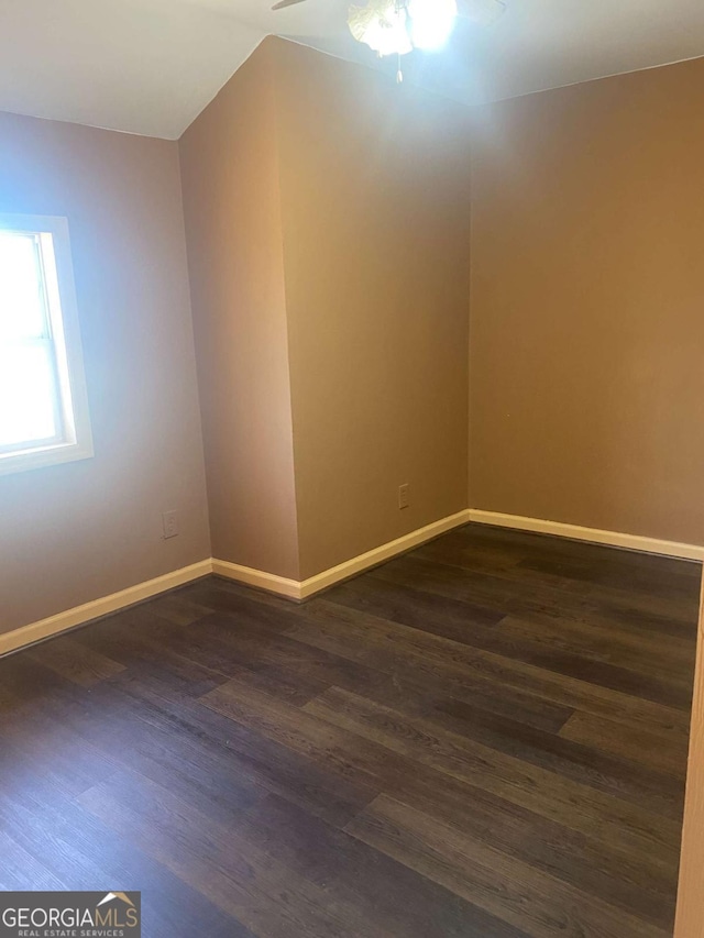 unfurnished room with dark wood-style floors, baseboards, and a ceiling fan
