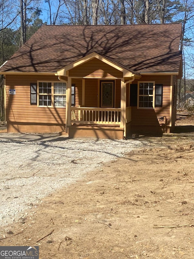 view of front of house featuring roof with shingles and covered porch
