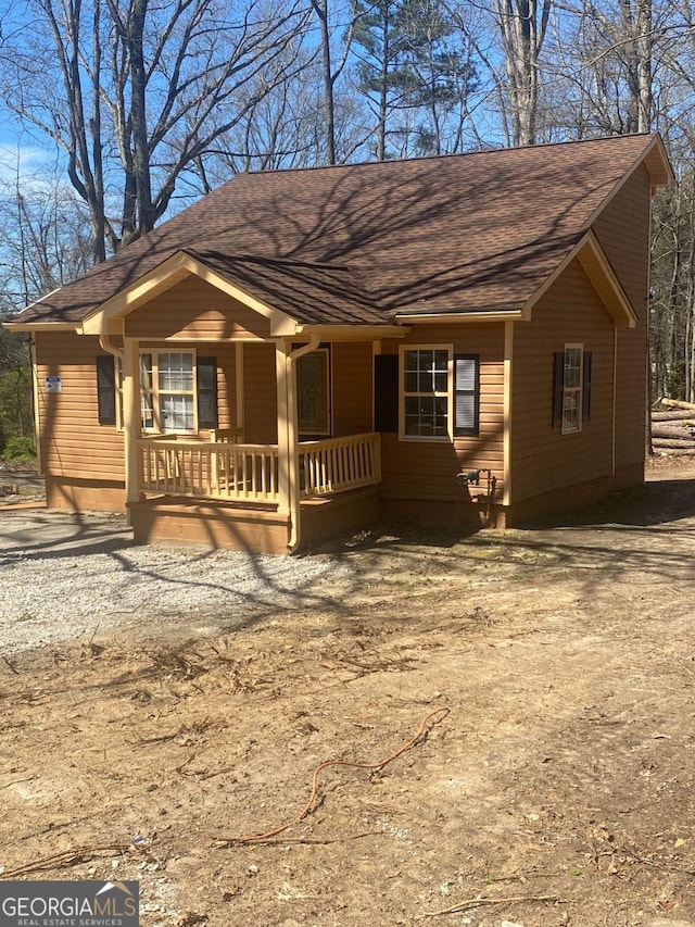 exterior space featuring roof with shingles and a porch