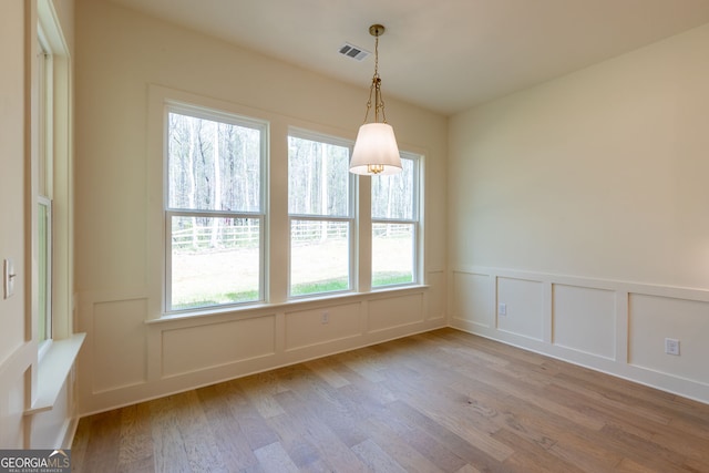 8415 Beryl Overlook, Gainesville, GA 30506 - unfurnished dining area featuring healthy amount of natural light, a decorative wall, wood finished floors, and a wainscoted wall