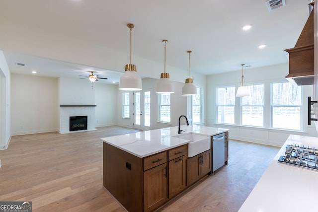 8415 Beryl Overlook, Gainesville, GA 30506 - kitchen featuring a sink, dishwashing machine, stainless steel gas cooktop, a ceiling fan, and light wood-style floors