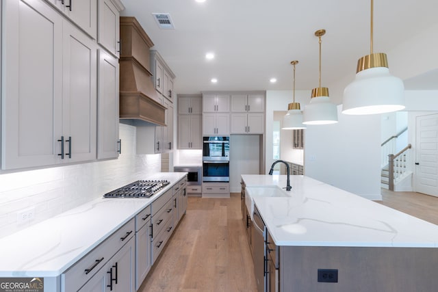 8415 Beryl Overlook, Gainesville, GA 30506 - kitchen featuring appliances with stainless steel finishes, a spacious island, backsplash, light wood finished floors, and recessed lighting