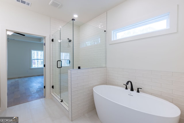 8415 Beryl Overlook, Gainesville, GA 30506 - bathroom featuring a shower stall, a freestanding bath, tile patterned flooring, tile walls, and recessed lighting