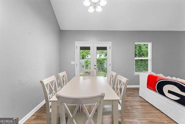 dining space with baseboards, french doors, wood finished floors, and lofted ceiling