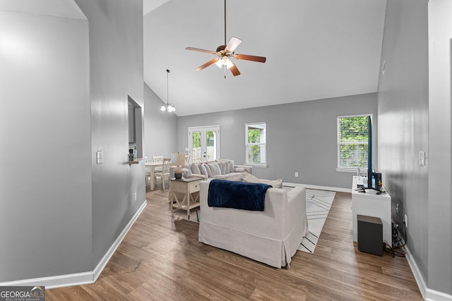 living room with high vaulted ceiling, baseboards, and a ceiling fan
