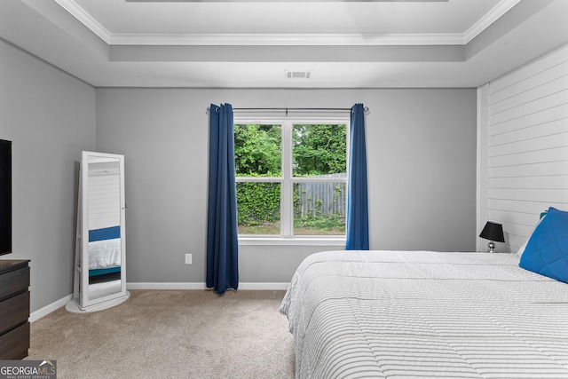 carpeted bedroom featuring crown molding, visible vents, and a raised ceiling