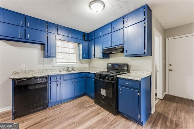 kitchen with a sink, light wood-type flooring, black appliances, and under cabinet range hood