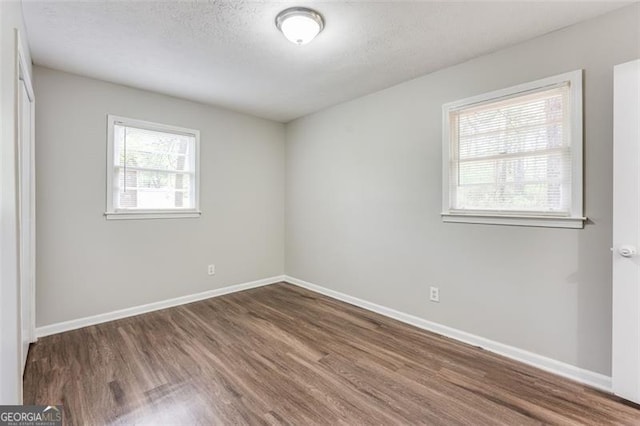 spare room featuring wood finished floors and baseboards