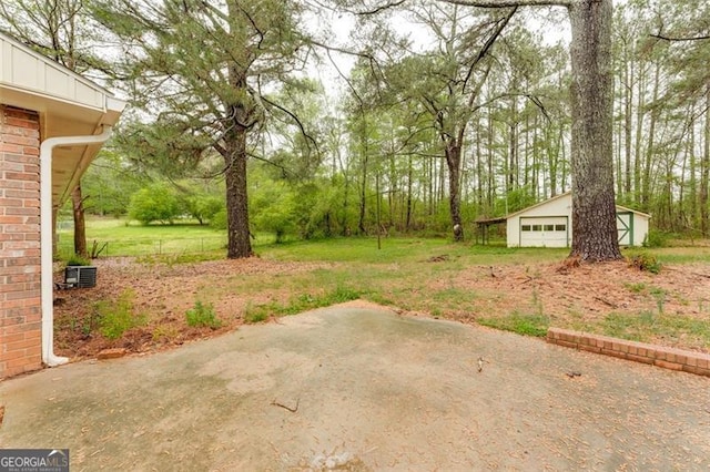 view of yard featuring a patio, an outbuilding, and a garage