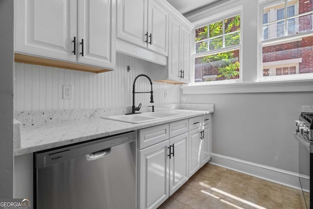 kitchen with stainless steel appliances, white cabinets, baseboards, and a sink