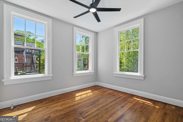 empty room with baseboards, ceiling fan, and wood finished floors