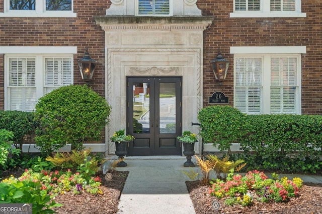 entrance to property featuring french doors and brick siding