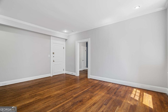 unfurnished room featuring crown molding, wood finished floors, and baseboards