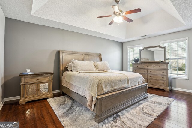 161 Hunters Chase, Mcdonough, GA 30253 - bedroom with dark wood finished floors, a ceiling fan, visible vents, a raised ceiling, and baseboards
