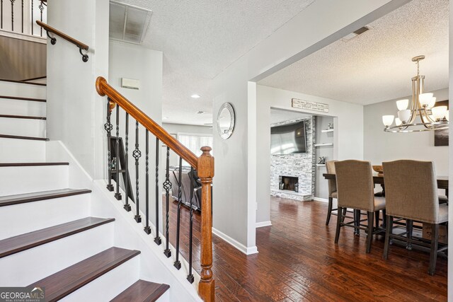 161 Hunters Chase, Mcdonough, GA 30253 - staircase with visible vents, an inviting chandelier, hardwood / wood-style flooring, and a textured ceiling