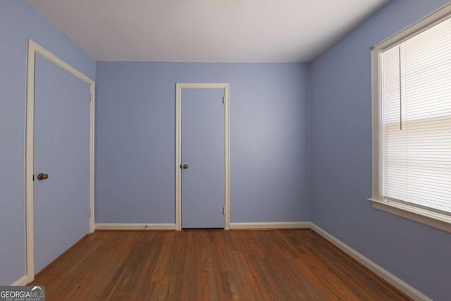 unfurnished room featuring baseboards and wood finished floors