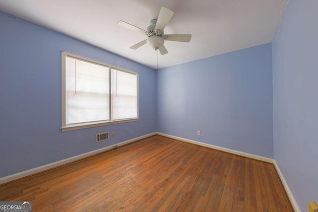 unfurnished room with wood finished floors, ceiling fan, baseboards, and visible vents