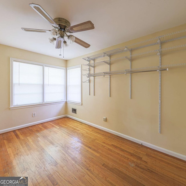 unfurnished room with light wood finished floors, visible vents, baseboards, and ceiling fan
