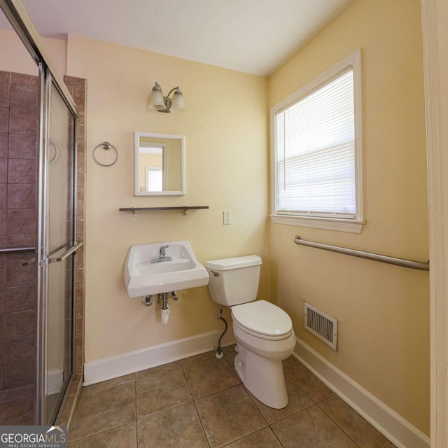 full bath featuring a stall shower, tile patterned floors, toilet, visible vents, and a sink
