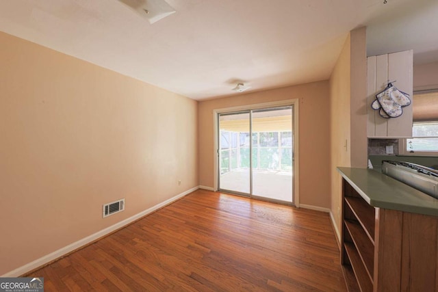 unfurnished dining area with wood finished floors, baseboards, and a wealth of natural light