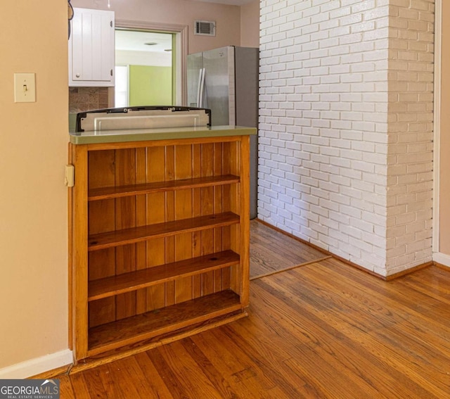staircase featuring visible vents, baseboards, and wood finished floors