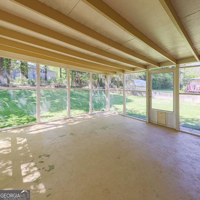 unfurnished sunroom featuring beamed ceiling