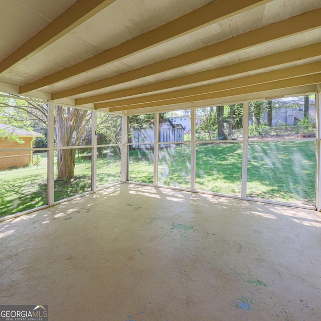 unfurnished sunroom with beam ceiling