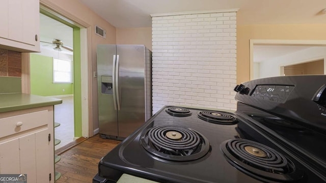 kitchen with visible vents, stainless steel fridge, dark wood-style flooring, black / electric stove, and white cabinetry