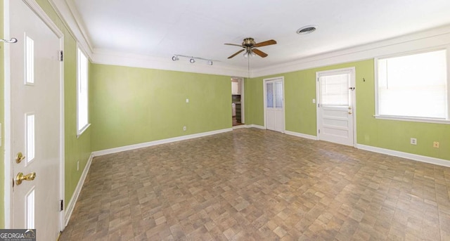 empty room featuring visible vents, baseboards, ornamental molding, ceiling fan, and rail lighting