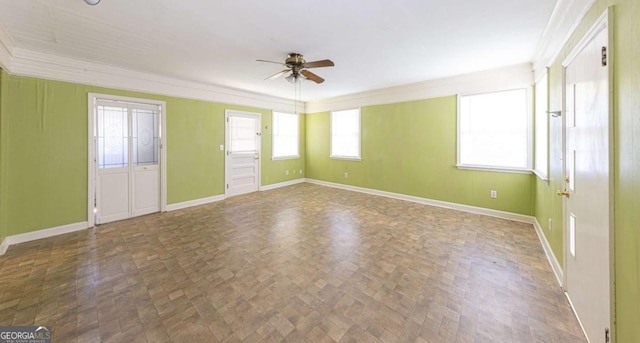 unfurnished room featuring ornamental molding, ceiling fan, and baseboards