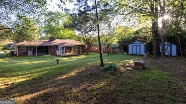 view of yard featuring a storage shed, an outdoor structure, and a sunroom