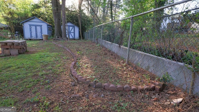 view of yard featuring a shed, an outdoor structure, and fence